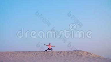 健康的年轻美女，日出时在海边打坐，伸展身体，练习瑜伽